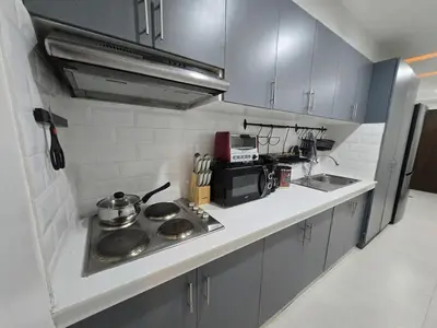 a small kitchen with a stove and a microwave at BGC Center Decent 74sqm, 2br, 2baths, 4beds with maid quarter in Manila