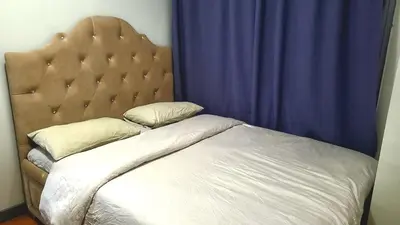 a bed in a bedroom with a blue curtain at BGC Center Decent 74sqm, 2br, 2baths, 4beds with maid quarter in Manila