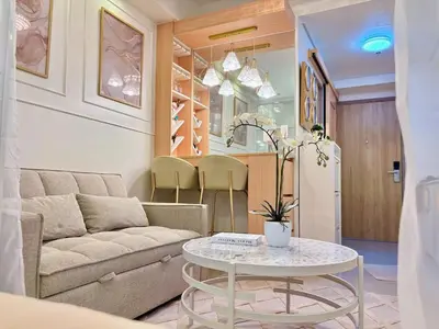 a living room with a couch and a table at Elegant Staycation Near Mall of Asia with Pool Access in Manila