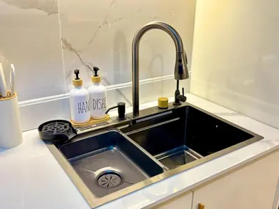 a sink in a kitchen with two bottles on it at Elegant Staycation Near Mall of Asia with Pool Access in Manila