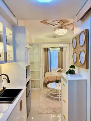 a kitchen with a sink and a room with a bed at Elegant Staycation Near Mall of Asia with Pool Access in Manila