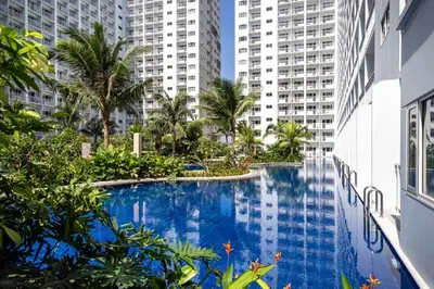 a swimming pool in the middle of a building with tall buildings at Hiraya Staycation in Manila