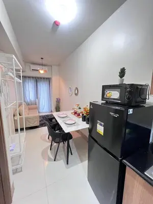 a kitchen and living room with a refrigerator and a table at UNISTAY Shore 3 Tower 2 Pool Vw w Bal in Manila