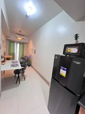 a kitchen and living room with a refrigerator and a table at UNISTAY Shore 3 Tower 2 14 Flr w Bal in Manila