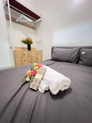 a bed with a towel and flowers on it at UNISTAY Shore 3 Tower 2 14 Flr w Bal in Manila