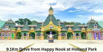a large yellow and green building with a clock tower at Happy Nook at Holland Park Condominium in Biñan