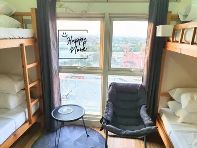 a room with a chair in front of a window at Happy Nook at Holland Park Condominium in Biñan
