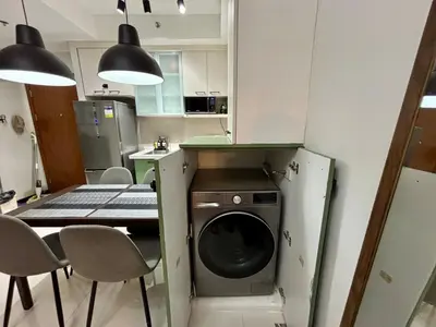 a kitchen with a washing machine and a table and chairs at Condo in Mandaluyong with BGC Skyline in Manila