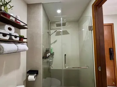 a bathroom with a shower with a glass door at Condo in Mandaluyong with BGC Skyline in Manila
