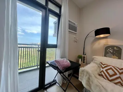 a bedroom with a balcony with a bed and a window at Okada Manila Gentry Manor Balcony 1br Unobstructed Scenic View in Manila
