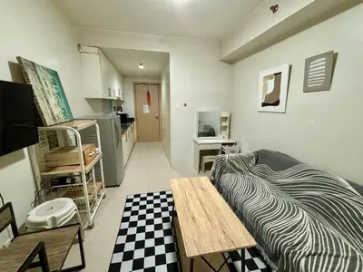 a room with a bed and a table in it at Sea Residences Pasay Cozy Studio Steps from SM Mall of Asia and MOA Arena in Manila