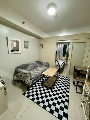 a room with a bed and a table in it at Sea Residences Pasay Cozy Studio Steps from SM Mall of Asia and MOA Arena in Manila