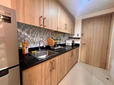 a kitchen with wooden cabinets and a sink at Shore Residences Pasay Balcony Studio Unobstructed View Near SM Mall of Asia in Manila