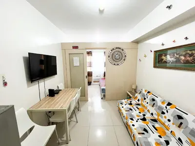 a living room with a cow print couch and a table at Sea Residences Navigators in Manila