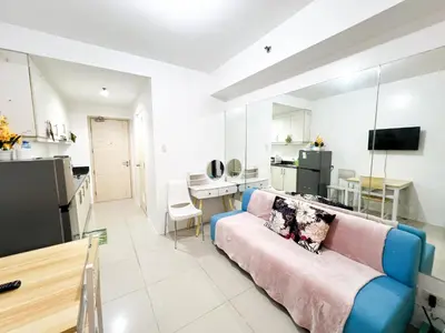 a living room with a couch and a kitchen at Sea Residences Navigators in Manila