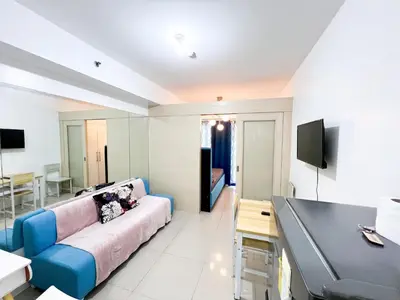 a living room with a couch and a television at Sea Residences Navigators in Manila