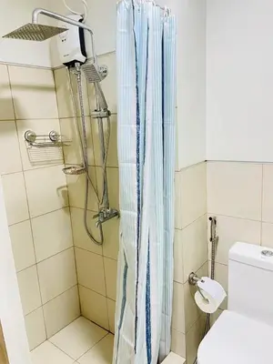 a shower with a blue shower curtain in a bathroom at Cozy condotel Field Residence in Manila