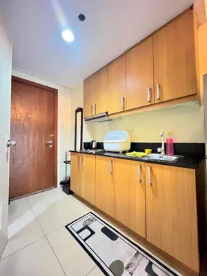 a kitchen with wooden cabinets and a sink at Shell Residences near MOA and NAIA by Mae in Manila