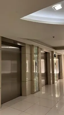 a hallway with elevators and doors in a building at Shell Residences near MOA and NAIA by Mae in Manila