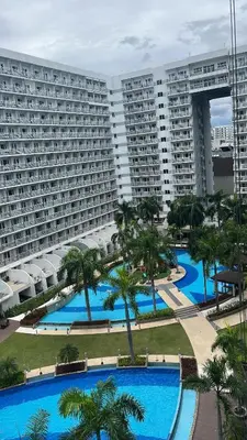 an aerial view of a large apartment building with palm trees at Shell Residences near MOA and NAIA by Mae in Manila