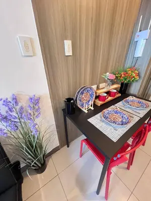a dining room table with plates and flowers on it at UNISTAY Coast Res R19 w Bal Sunset Vw Worldtrade in Manila
