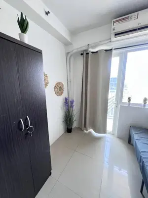 a room with a door with a couch and a window at UNISTAY Shore Res w Bal Manila Bay View nr MOA in Manila