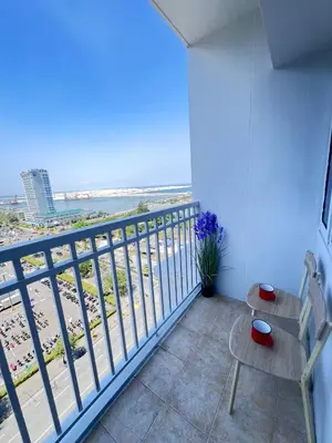 a balcony with a view of the beach at UNISTAY Shore Res w Bal Manila Bay View nr MOA in Manila