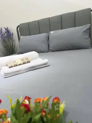 a white bed with pillows and flowers on it at UNISTAY Shore 3 Pool View w Balcony near MOA in Manila