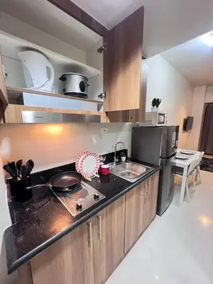 a kitchen with a sink and a stove top oven at UNISTAY Shore 3 Pool View w Balcony near MOA in Manila