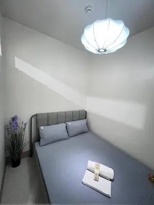 a bed in a room with a light at UNISTAY Shore 3 Pool View w Balcony near MOA in Manila