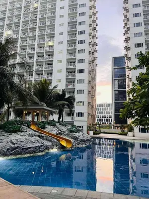 a pool with a slide in front of a large building at Wowstaycation in Manila