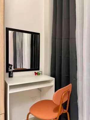 a room with a mirror and a chair and a table at Wowstaycation in Manila