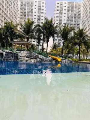 a swimming pool with a yellow slide in a city at Wowstaycation in Manila
