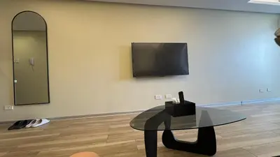 a room with a table and a tv on a wall at L CONDOTEL Apartment Near Okada Casino PITX MOA with Pool in Manila