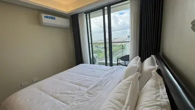 a bedroom with a bed with white sheets and a window at L CONDOTEL Apartment Near Okada Casino PITX MOA with Pool in Manila