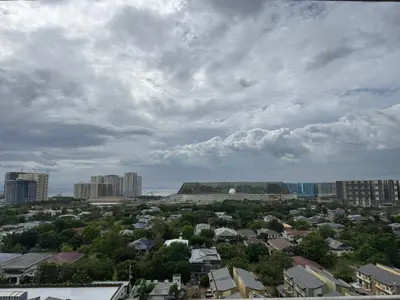 a city under a cloudy sky with buildings and trees at L CONDOTEL Apartment Near Okada Casino PITX MOA with Pool in Manila