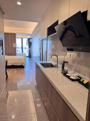 a kitchen with a sink and a living room with a bed at L CONDOTEL Apartment Near Okada Casino PITX MOA with Pool in Manila