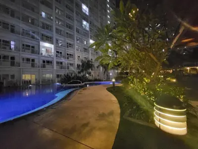 a large building with a swimming pool at night at Stonewood Suite by Staycationplus with FREE PARKING in Manila