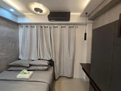 a bedroom with a bed and a window with curtains at Stonewood Suite by Staycationplus with FREE PARKING in Manila