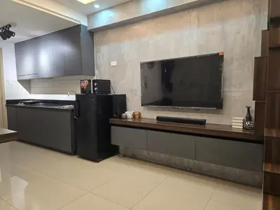 a kitchen with a black refrigerator and a tv on the wall at Stonewood Suite by Staycationplus with FREE PARKING in Manila