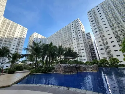 a large swimming pool in front of tall buildings at Stonewood Suite by Staycationplus with FREE PARKING in Manila