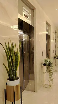 a potted plant in a lobby with a elevator at 16 Guest for Group at Palm Tower 2 Makati RM 203 in Manila