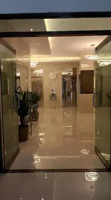 an empty lobby with glass doors and potted plants at 16 Guest for Group at Palm Tower 2 Makati RM 203 in Manila