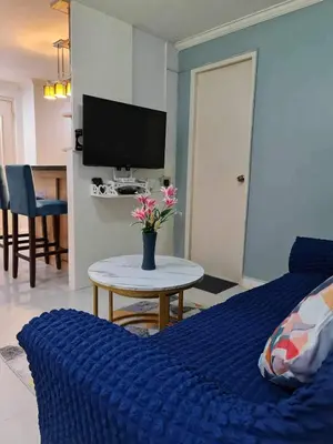 a bedroom with a blue bed and a table with flowers on it at 16 Guest for Group at Palm Tower 2 Makati RM 203 in Manila