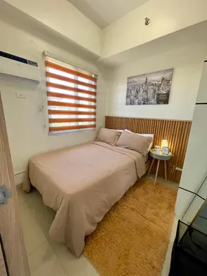 a small bedroom with a bed and a window at Empirestatecation at Leaf Residences in Manila
