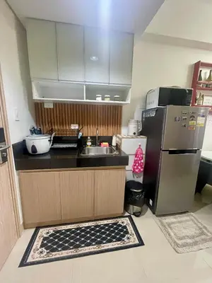 a small kitchen with a sink and a refrigerator at Empirestatecation at Leaf Residences in Manila