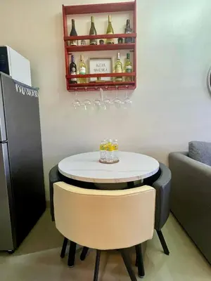a kitchen with a table and two chairs and a refrigerator at Empirestatecation at Leaf Residences in Manila