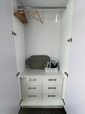 a closet with a white dresser and a chair at 1BR Condotel in Azure Urban Resort near NAIA #TRO1 in Manila