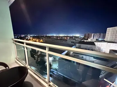 a balcony with a view of a city at night at 1BR Condotel in Azure Urban Resort near NAIA #TRO1 in Manila