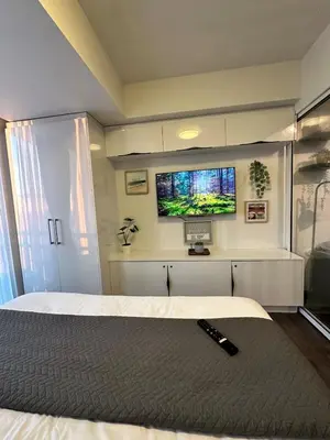 a bedroom with a bed and a flat screen tv at 1BR Condotel in Azure Urban Resort near NAIA #TRO1 in Manila